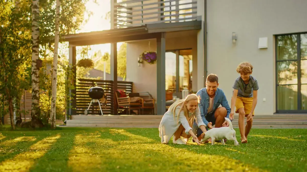 A family in the yard of a home they own