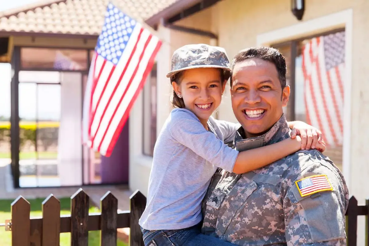 A military family together outside their home