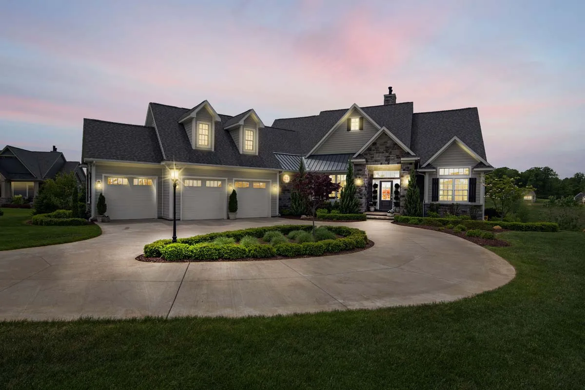 A well-lit home at dusk, windows glowing